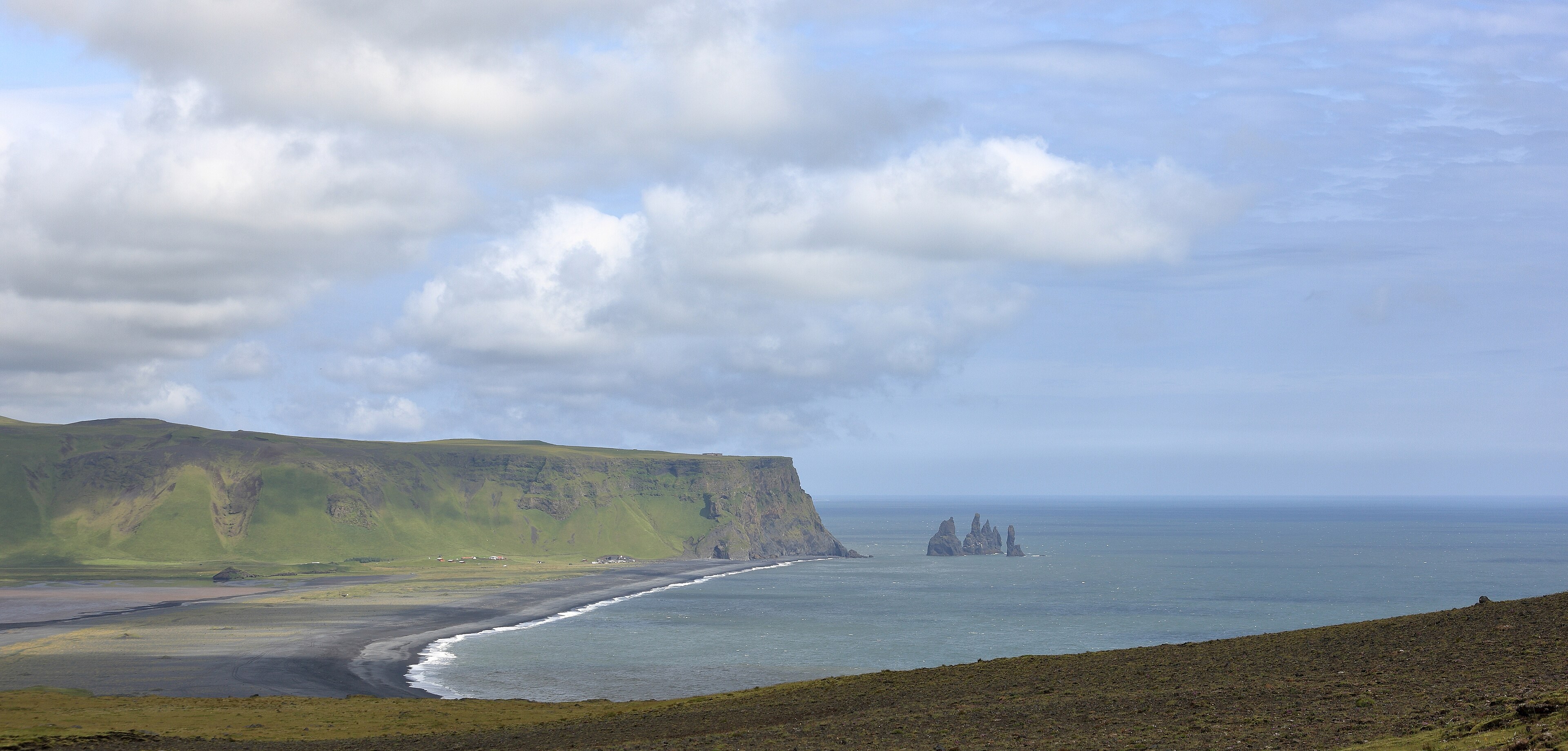 The black sand of Reynisfjara with the Reynisdrangar sea stacks offshore
