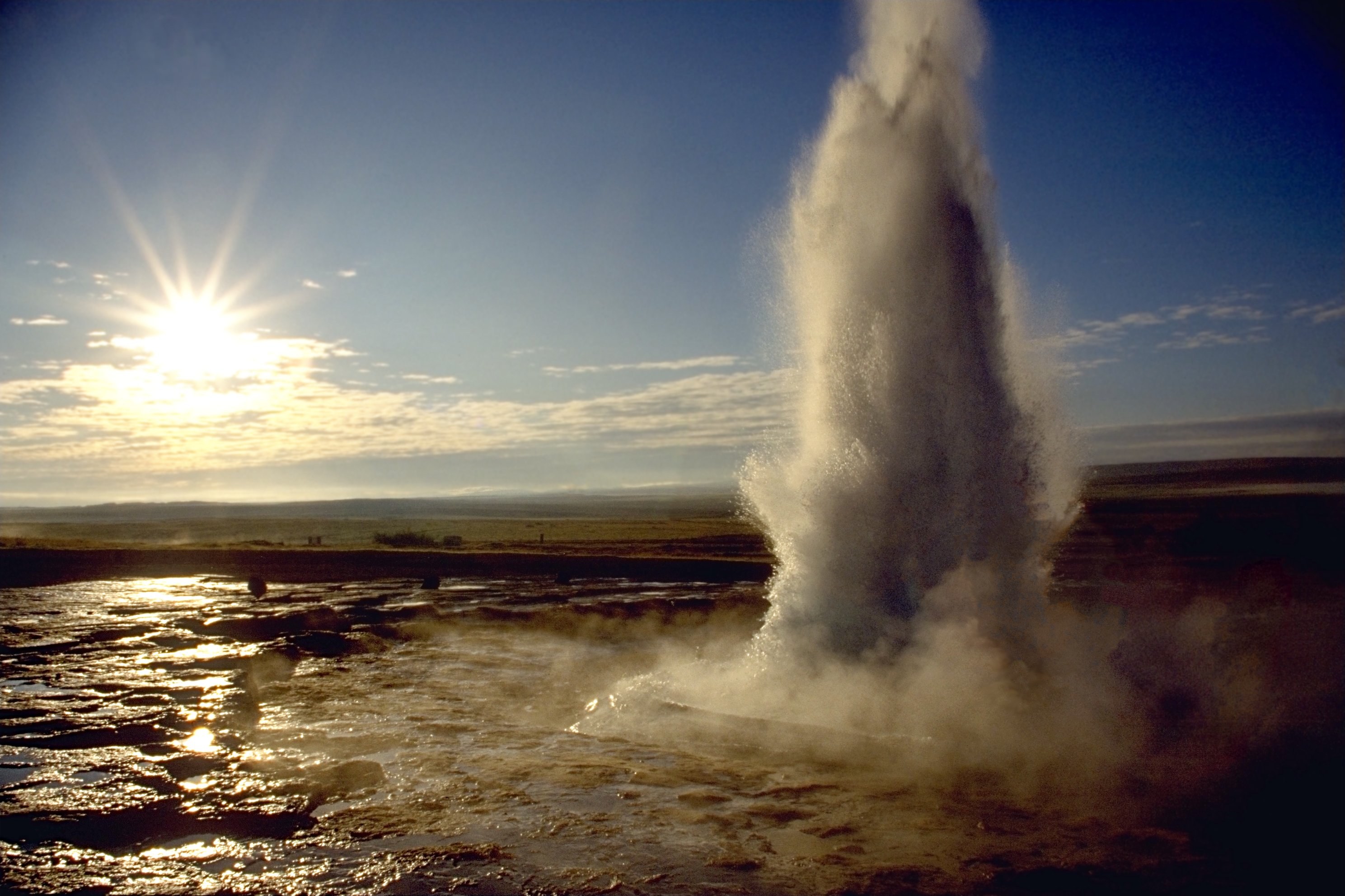 Strokkur erupting, a column of water and steam over the Geysir geothermal field